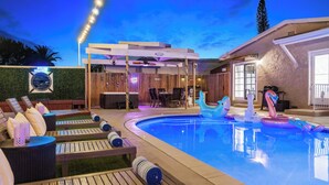 Un espace piscine avec des chaises longues et un coin salon abrité.