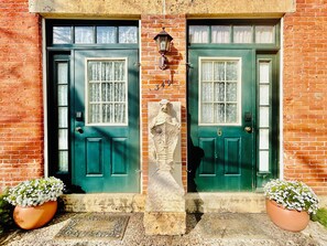 Traditional entrance with a stone statue and potted plants.