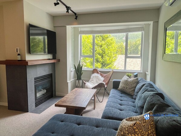 A living room with a fireplace, sofa, and a television.
