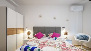 A hotel room with a bed, two nightstands, a chair, and an air conditioning unit. - Top Location Beach & Downtown Split Apartment Park (Split)