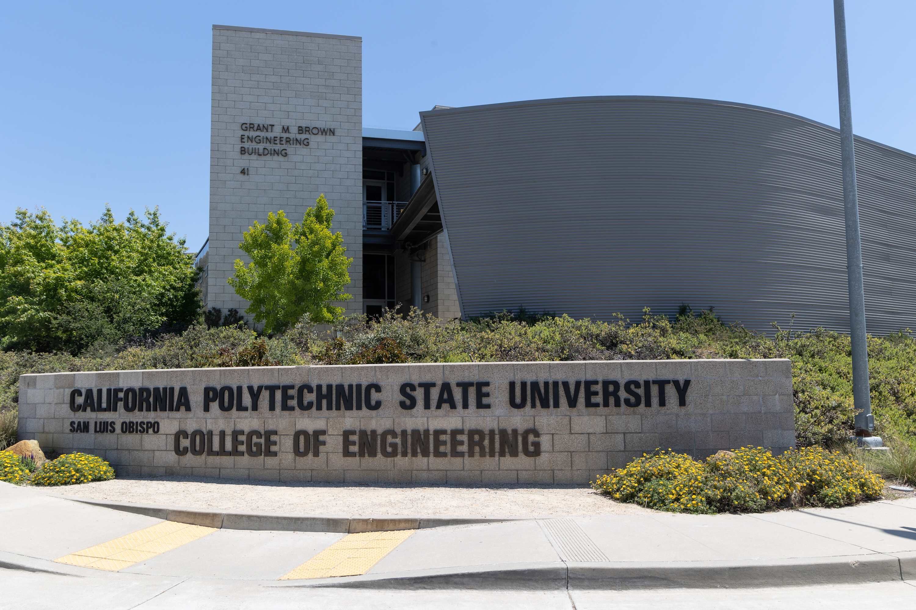 La entrada a la Universidad Politécnica Estatal de California, Facultad de Ingeniería, con un letrero destacado y una fachada de edificio moderna.