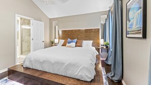 A spacious bedroom with a large bed, a ceiling fan, a wooden headboard, and a framed picture on the wall. - Close to Kalahari King Beds Fast Wifi 3BR (Round Rock)