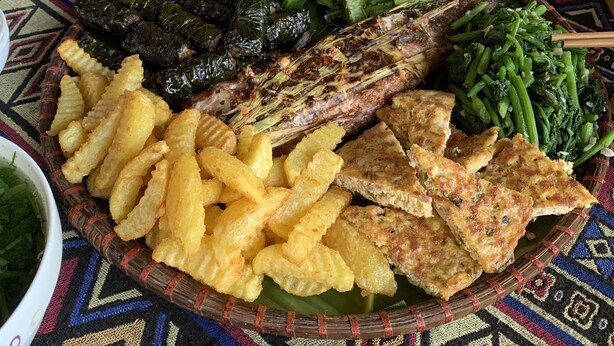A table with a variety of dishes including fried items, grilled fish, and vegetables. - Pù Luông Ecocharm (Pu Luong)