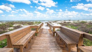 A wooden boardwalk with benches leading to a beach. - Amazing Ocean and Pool Views! Balcony, Elevator, Minutes to Historic Downtown, $300 in Free Tickets! (St. Augustine)