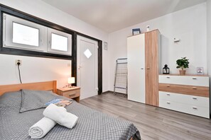 A hotel room with a bed, a nightstand, a wardrobe, a window, and a door. - AquaHaven With Private Pool And Wellness (Veliko Trgovisce)
