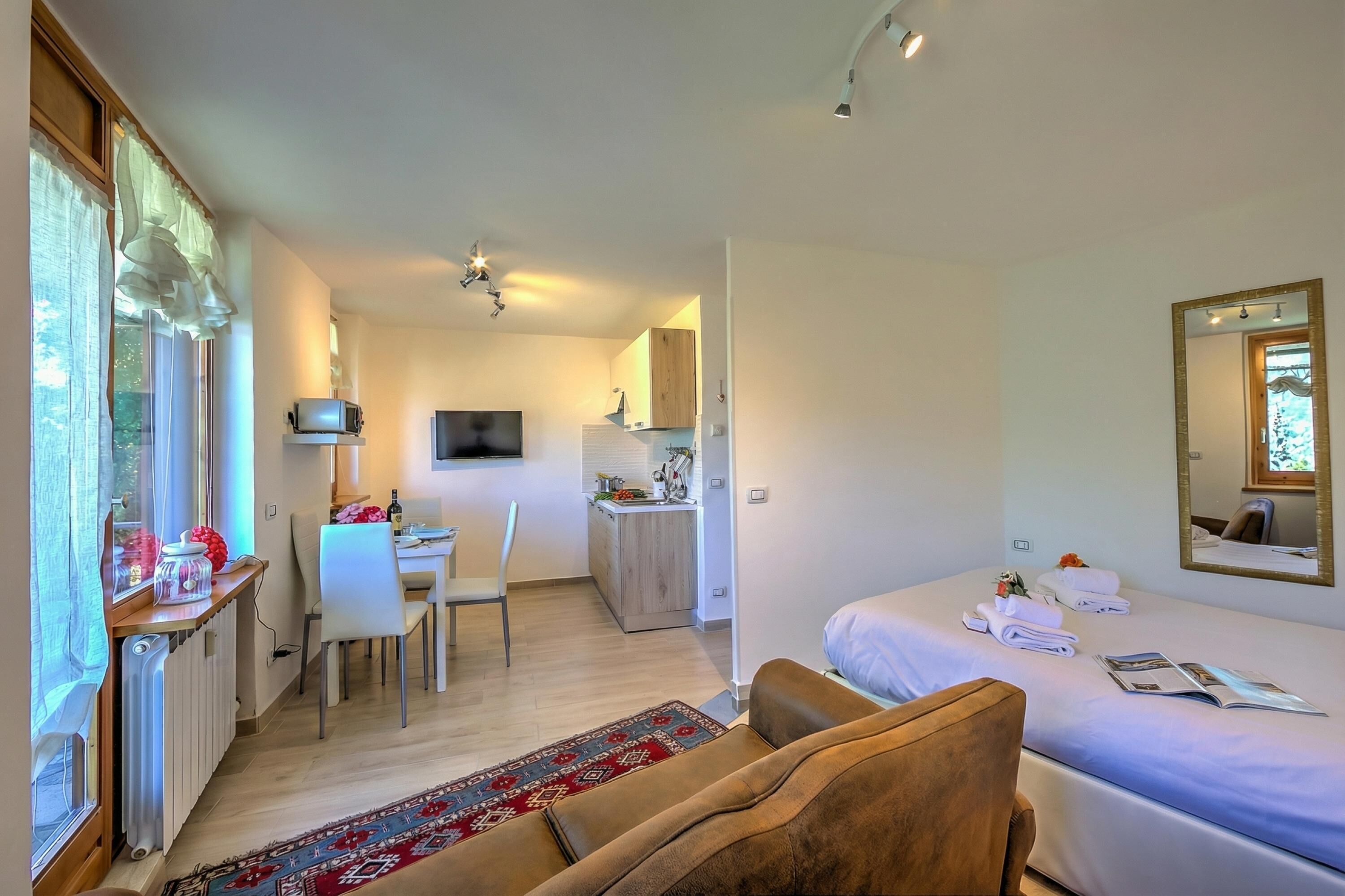 Une chambre d’hôtel moderne équipée d’un lit, d’un bureau et d’une kitchenette.