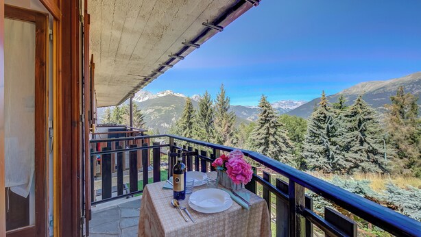 A balcony with a table set for two, overlooking a mountainous landscape. - Studio La Borracina Mountain View (Sauze d'Oulx)