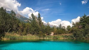 A clear lake surrounded by trees and mountains. - Studio La Borracina Mountain View (Sauze d'Oulx)