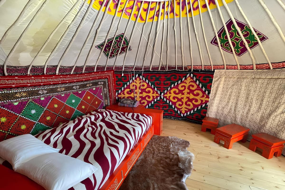 A room with a bed, a rug, and a wooden floor.