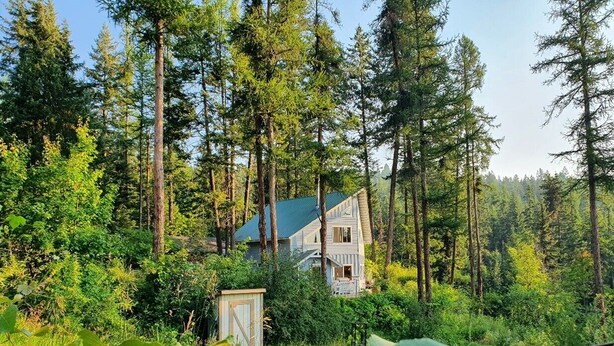 A two-story house surrounded by dense forest. - Charming house with orchard and pond close to Flathead Lake (Rollins)