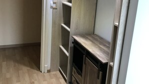 Een kamer met een houten vloer, inbouwkasten en een kast.