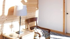 A wooden interior with a staircase, a door, and a window.
