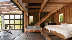 Un dormitorio moderno con una cama grande, techo de madera y vistas al exterior.