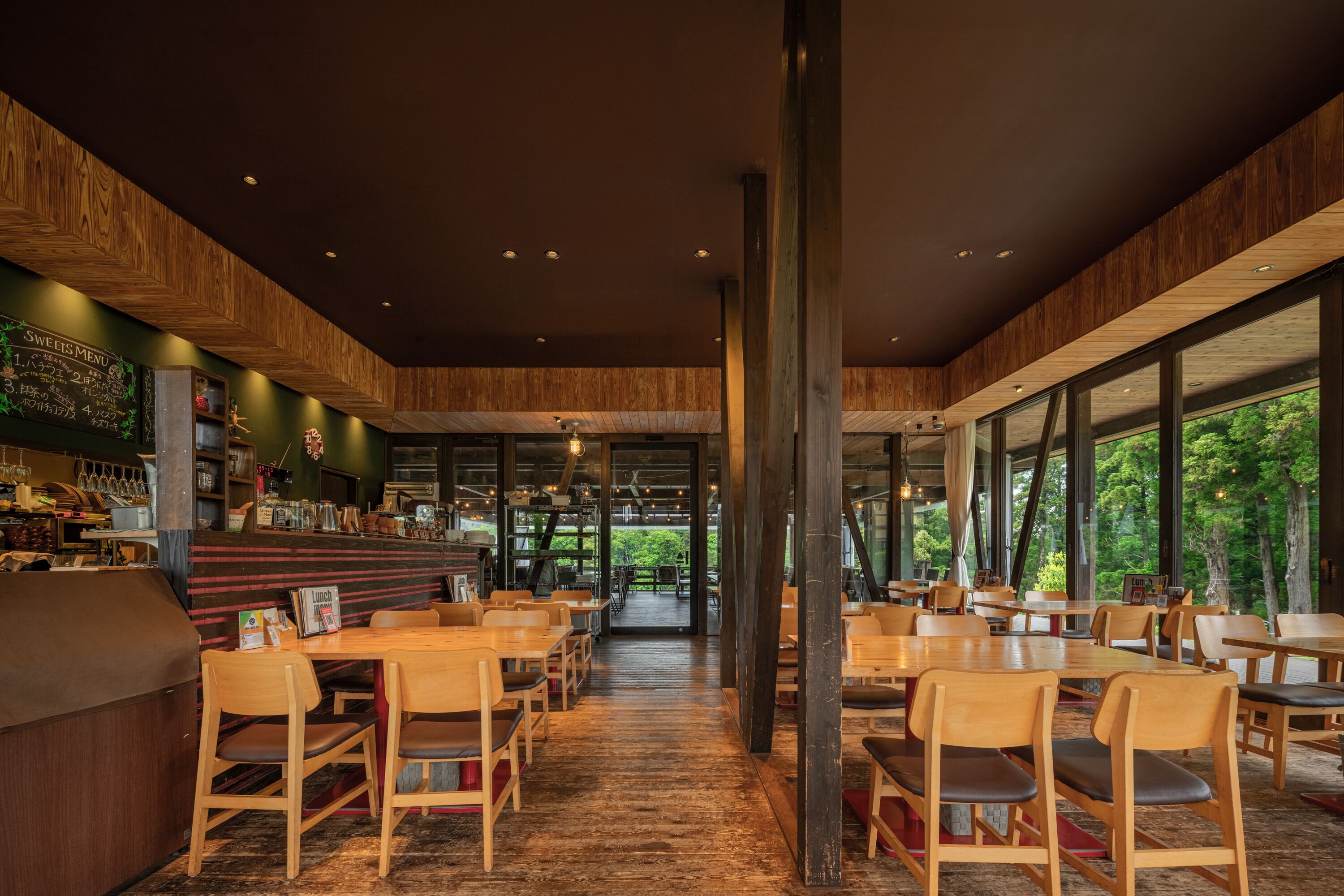 A restaurant with wooden interior, tables, chairs, and a bar area.