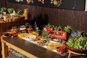 Buffet com diversos tipos de comida e uma mesa de saladas.