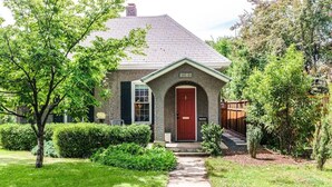 A two-story house with a red door and a mailbox.