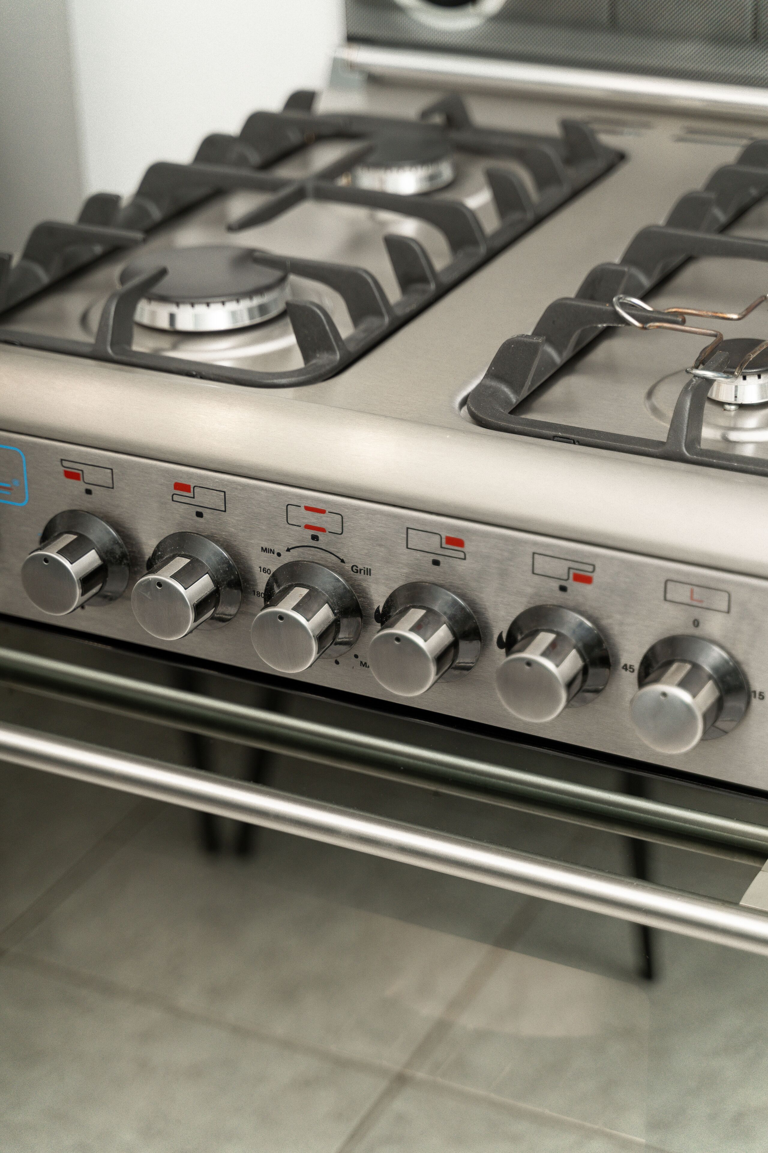A gas stove with multiple burners and control knobs.