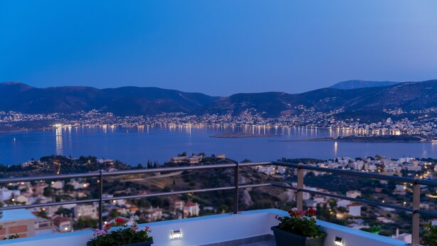 A rooftop terrace with a table and chairs, overlooking a cityscape and a body of water. - MTC-Sea & sky by Valeria near airport (Markopoulo Mesogaias)