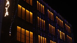 Un hotel con un letrero destacado que dice "HOTEL IDHAYA" y "JOHN & SONS STORE".