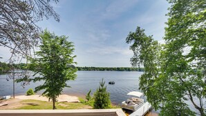 Blick auf einen See von einer Terrasse aus, mit einem Boot, das im Wasser liegt.