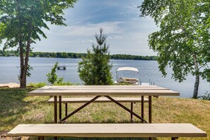 Une table de pique-nique avec vue sur un lac et un bateau en arrière-plan.