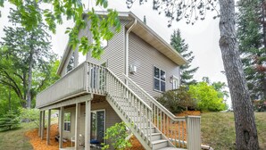 Une maison à deux étages dotée d’un porche et d’un escalier menant à l’étage supérieur.