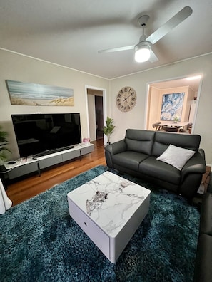 Relax in this stylish living room with a flat-screen TV, comfortable sofa, and a cozy coffee table.