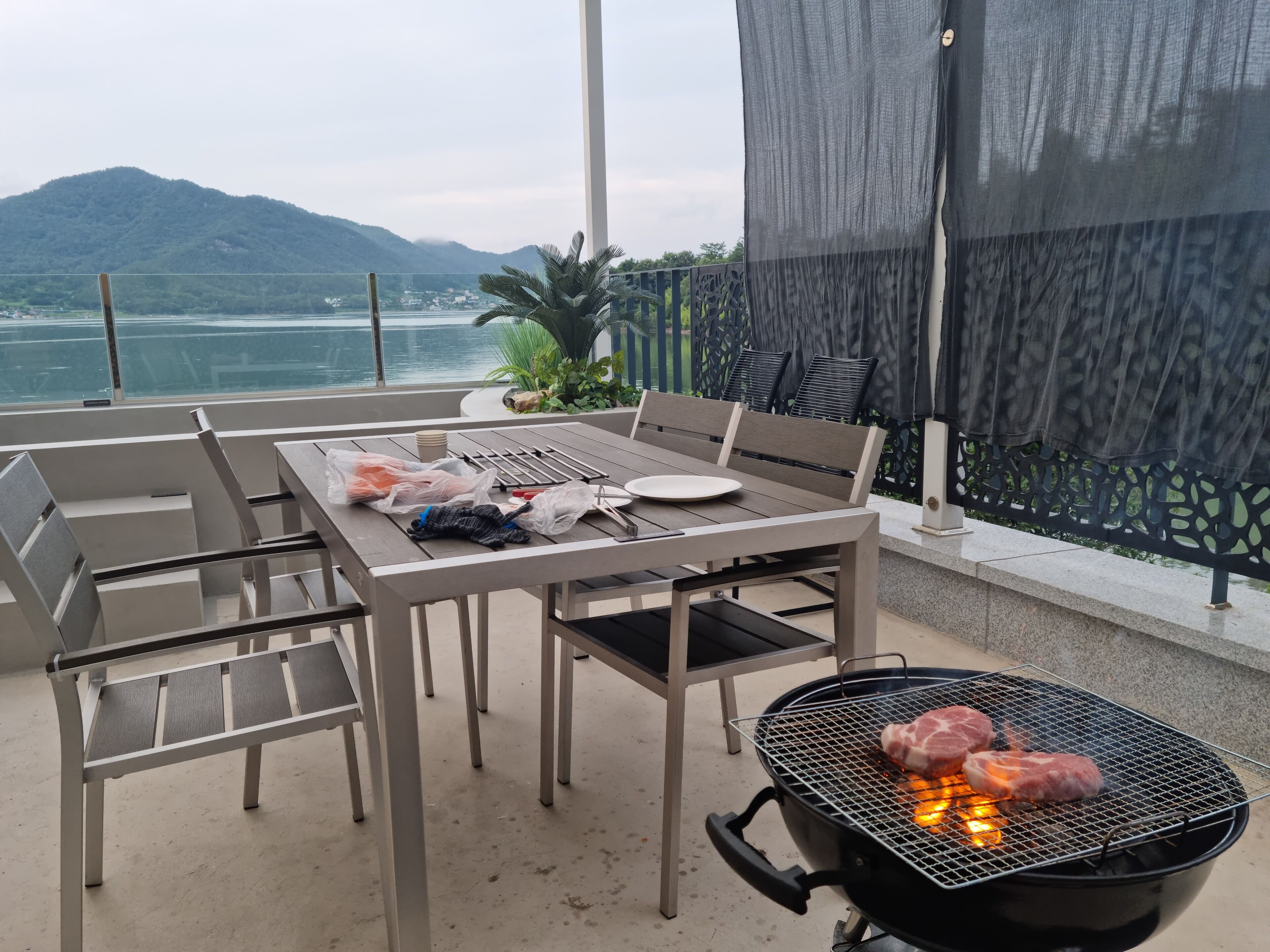 Un área de comedor al aire libre con una parrilla, sillas y una mesa.