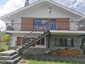 A two-story house with a stone facade, a wooden balcony, and a staircase leading to the upper floor. - House overlooking the Cadí-Moixeró massif, traditional from the 70s with magical (Lles de Cerdanya)