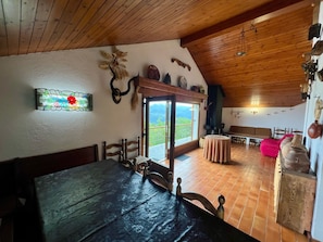 A rustic dining area with a wooden table and chairs, a stained glass window, and a view of the outdoors. - House overlooking the Cadí-Moixeró massif, traditional from the 70s with magical (Lles de Cerdanya)