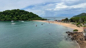A beach with boats, a sandy shore, and a forested hill. - Live an Adventure in Taboga 2 (Provincia de Panamá)