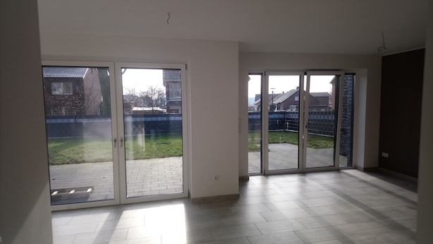 Amplia habitación con grandes puertas correderas de vidrio que dan a un patio.