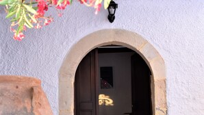 An arched doorway leading into a building with a textured wall and a lantern above it. - Relaxing villa with amazing view (Garazo)