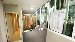 Bancada de recepção com uma lista de preços de quartos na parede.