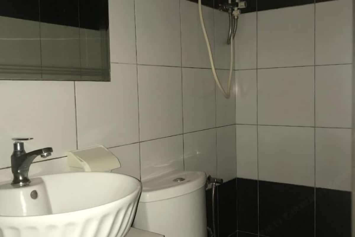 A bathroom with a white sink, a toilet, and a shower.