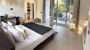 A modern bedroom with a large bed, a desk, and a view of the outdoors. - Kuwa Zanzibar (Kiwengwa)