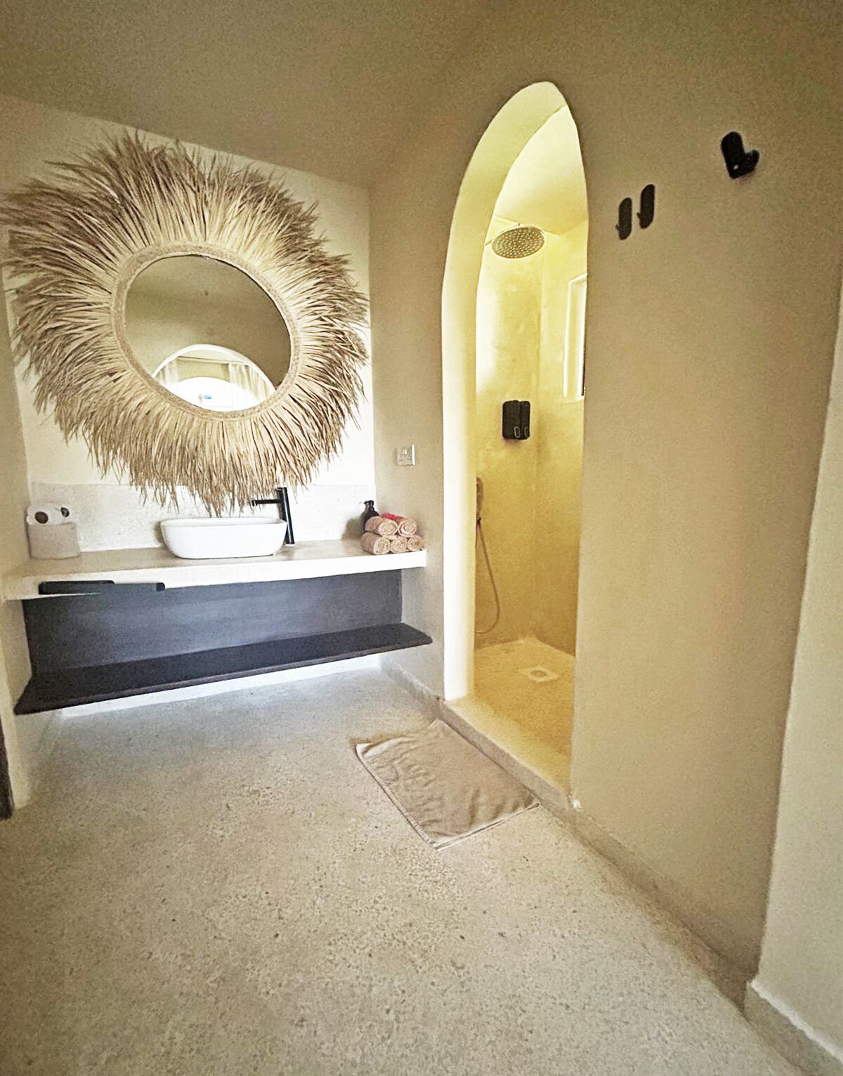 Een badkamer met een grote spiegel, een witte wastafel en een douche.