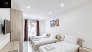 Ein Hotelzimmer mit zwei Betten, einem Fernseher und einem Bild an der Wand.