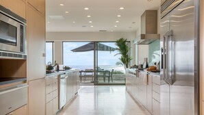 A modern kitchen with stainless steel appliances, a large window, and a view of the ocean. - Jewel by AvantStay | Panoramic Ocean Views in La Jolla! (San Diego)