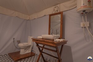 Un baño con tocador de madera, lavamanos blanco, espejo y retrete.