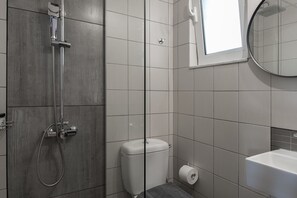 Ein Badezimmer mit Dusche, Toilette und Waschbecken.
