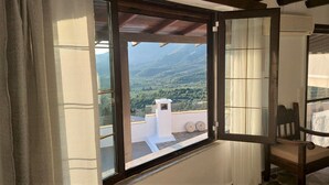Une pièce dotée d’une grande fenêtre donnant sur un paysage montagneux.