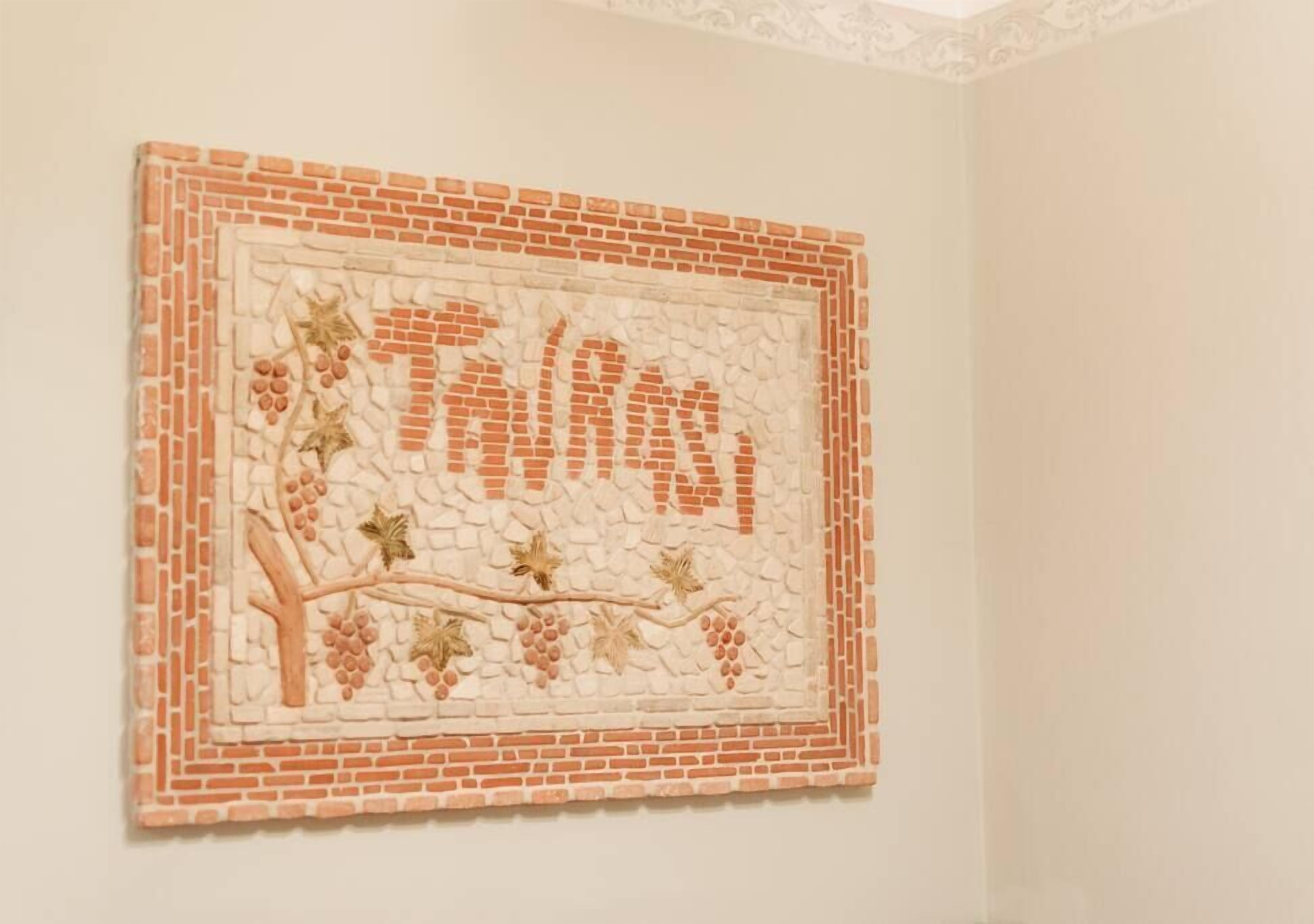 A wall art piece with a brick pattern and grapevines.