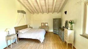 A bedroom with a bed, bedside tables, a wardrobe, and a dresser. - Cozy farmhouse in the mountains. Animals are welcome (Toscolano Maderno)
