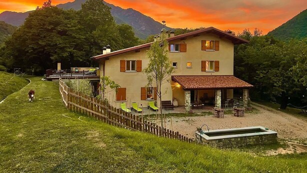 A two-story house with a balcony, surrounded by a wooden fence and a small pool. - Cozy farmhouse in the mountains. Animals are welcome (Toscolano Maderno)