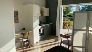 Una cocina compacta con comedor, una mesa pequeña y sillas.