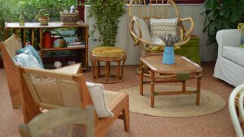 Relax in a serene garden setting surrounded by lush greenery and comfortable outdoor seating.