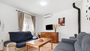 Ein Wohnzimmer mit einer Couch, einem Holztisch, einem Fernseher und einem Schrank.