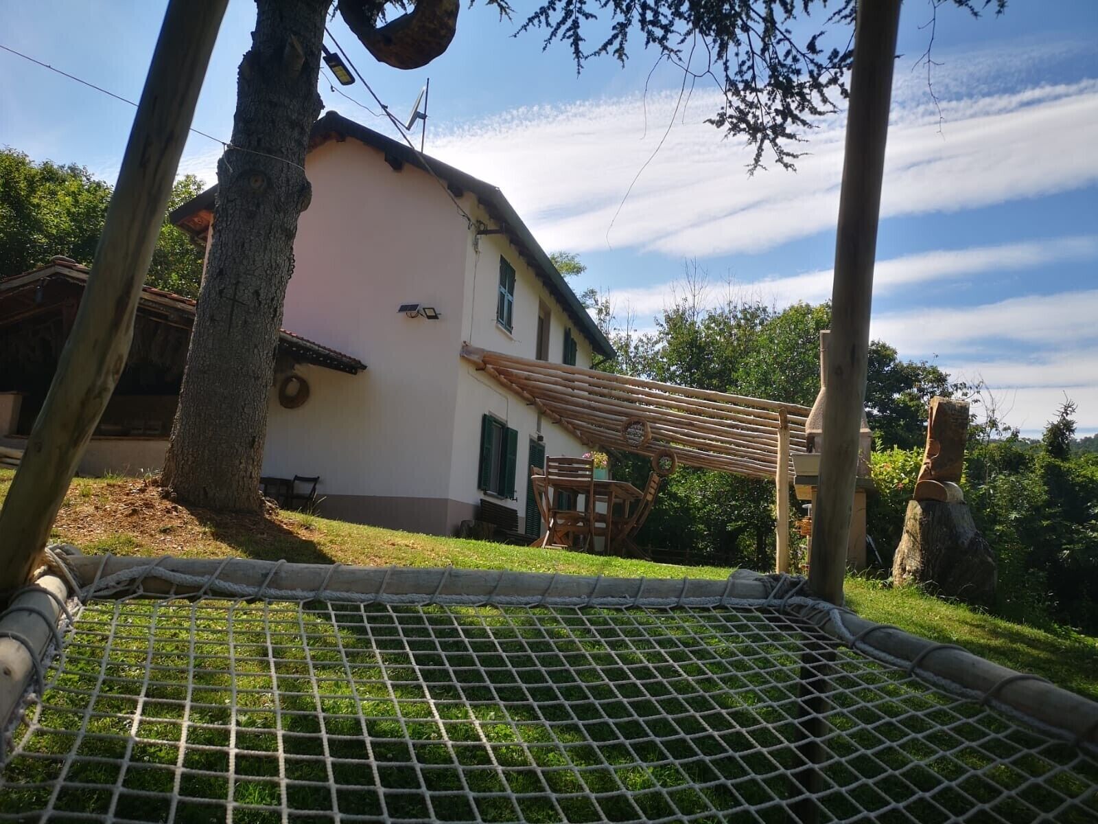 Une maison avec un toit en pente, une terrasse en bois et une cour clôturée.