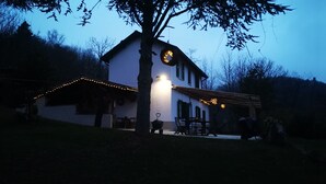 A house with a porch, a dining table, and a chair. - Holiday Home 'La Rosa sul Lago' Pet-Friendly with Private Garden, Spa, and Wi-Fi (Osiglia)